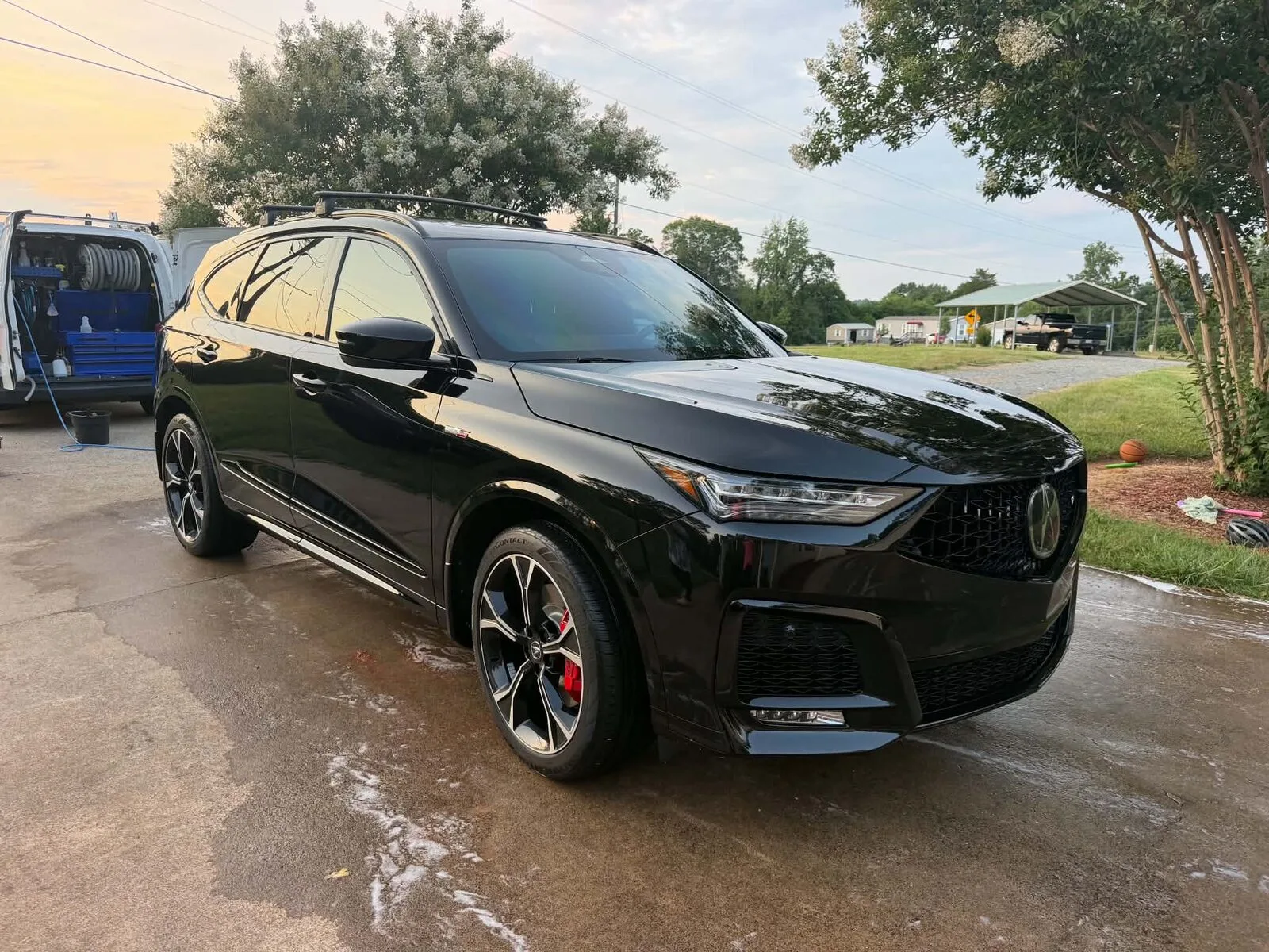 Glossy black Acura MDX SUV freshly detailed by Romeo's Detailing at sunset
