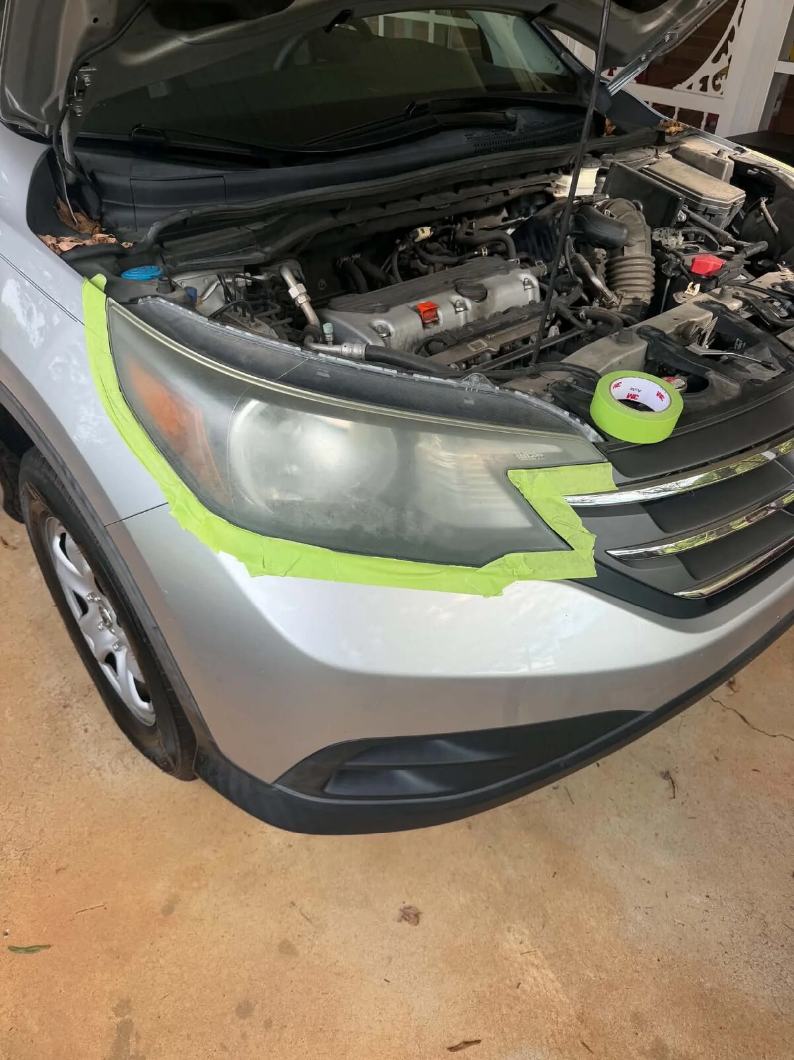 Cloudy, yellowed headlight on a silver Honda CR-V before headlight restoration by Romeo's Detailing
