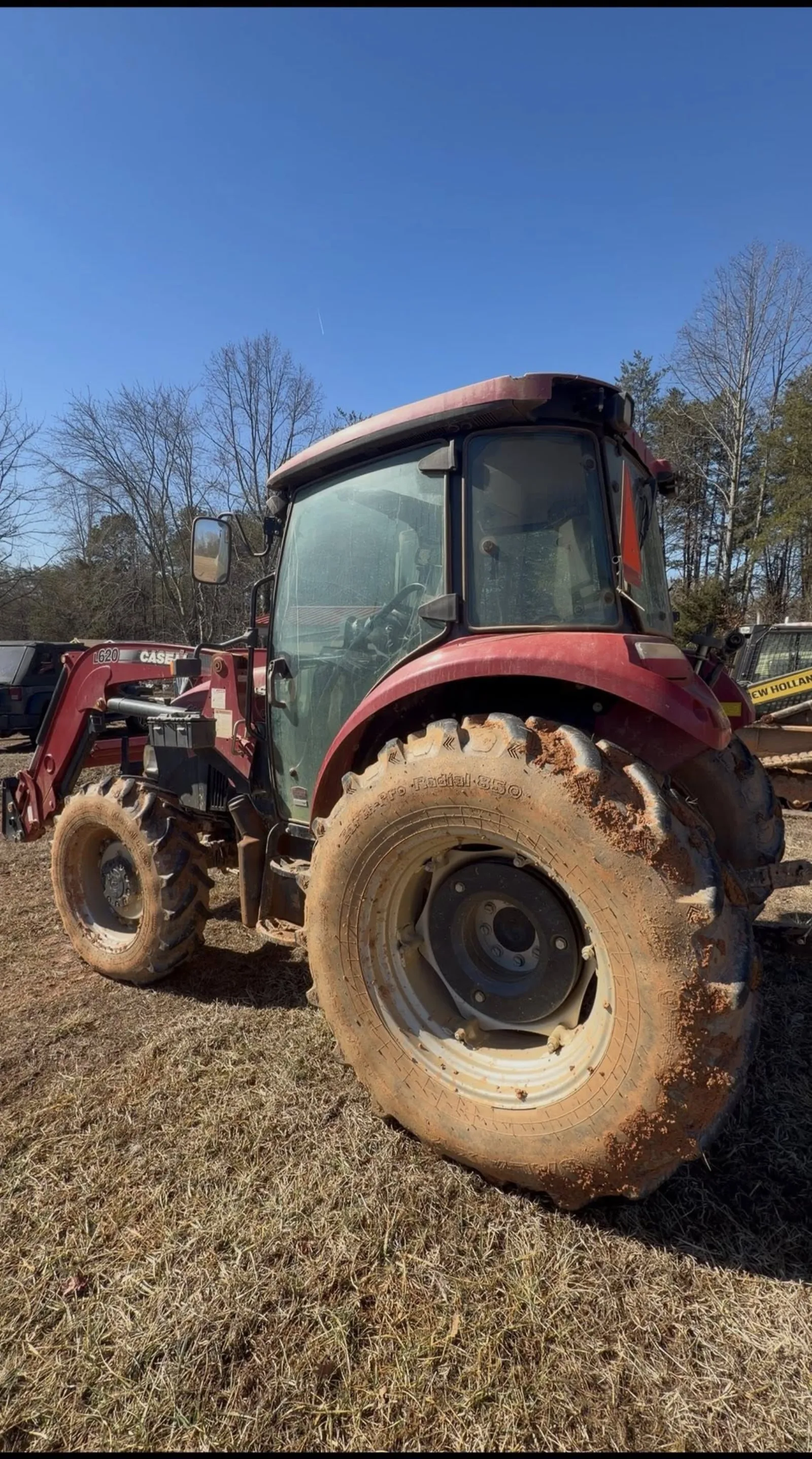Dirty red tractor covered in built-up grime before an on-site equipment detail by Romeo's Detailing
